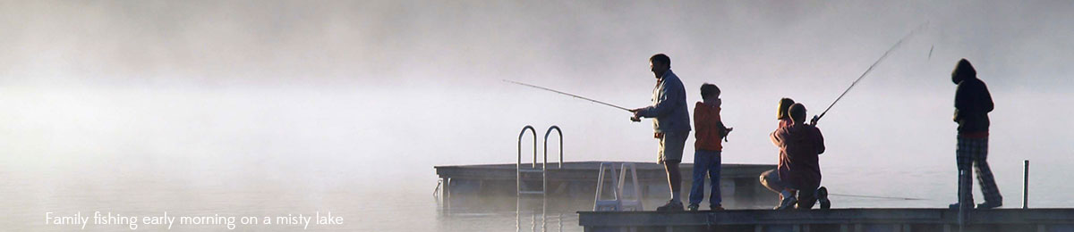 Family fishing early monring on a misty lake